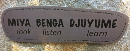 Picture of engraved plaque which reads ‘Miya, Benga, Djuyeme’ -  ‘Look, Listen Learn’